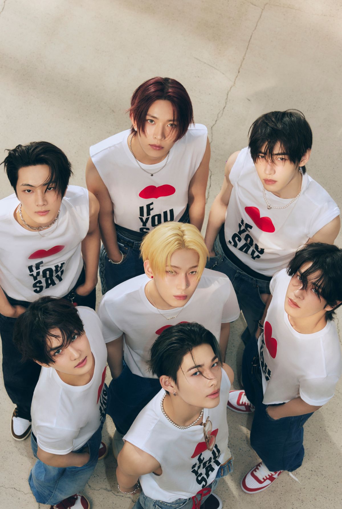 ENHYPEN photographed together from above in white graphic shirts